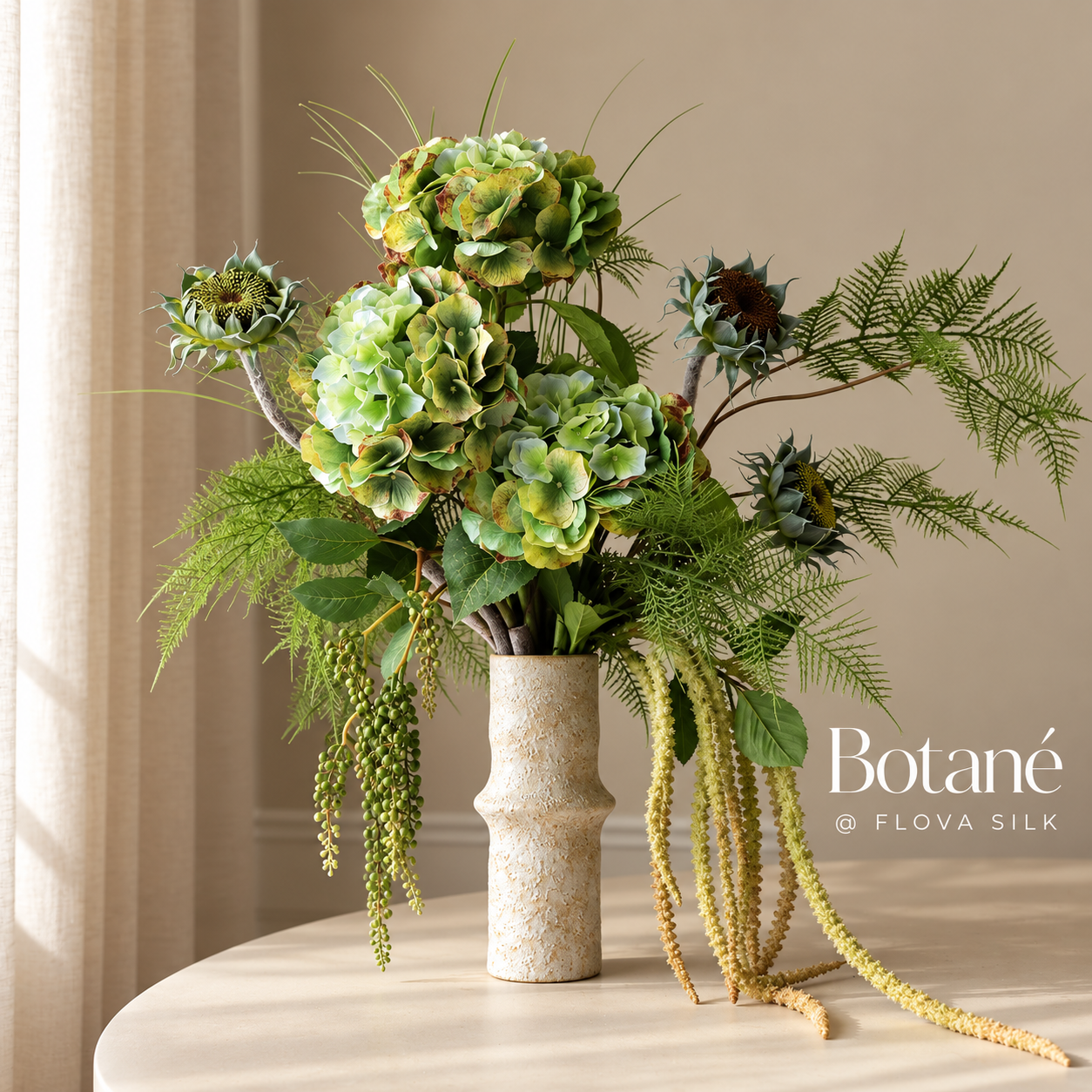 Mosslight luxury artificial flower arrangement by Botané at FLOVA SILK with soft green hydrangeas, ornamental grasses, decorative thistles and cascading greenery in a ceramic vase.