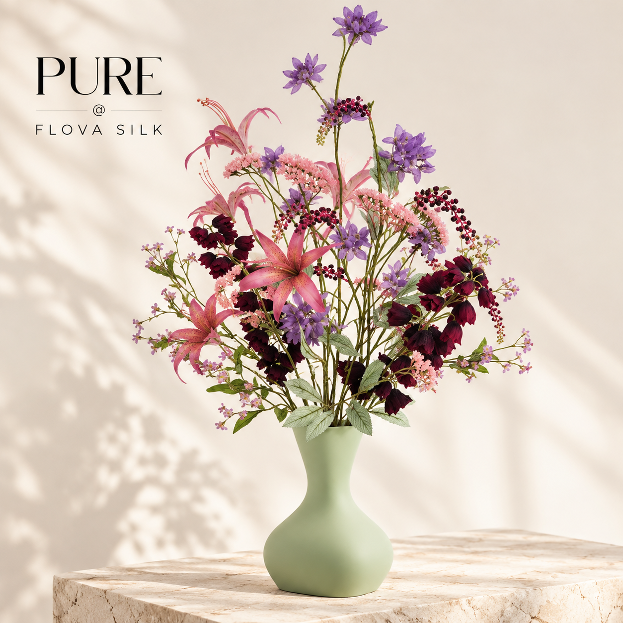 Fréjus Burgundy 120 cm luxury silk flower arrangement by PURE at FLOVA SILK displayed in a sage green vase on a stone table in an elegant neutral living room.