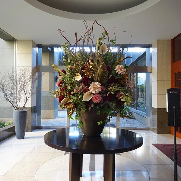 Groot luxe kunstbloemenarrangement in een vaas voor een ruime entree of ontvangstruimte