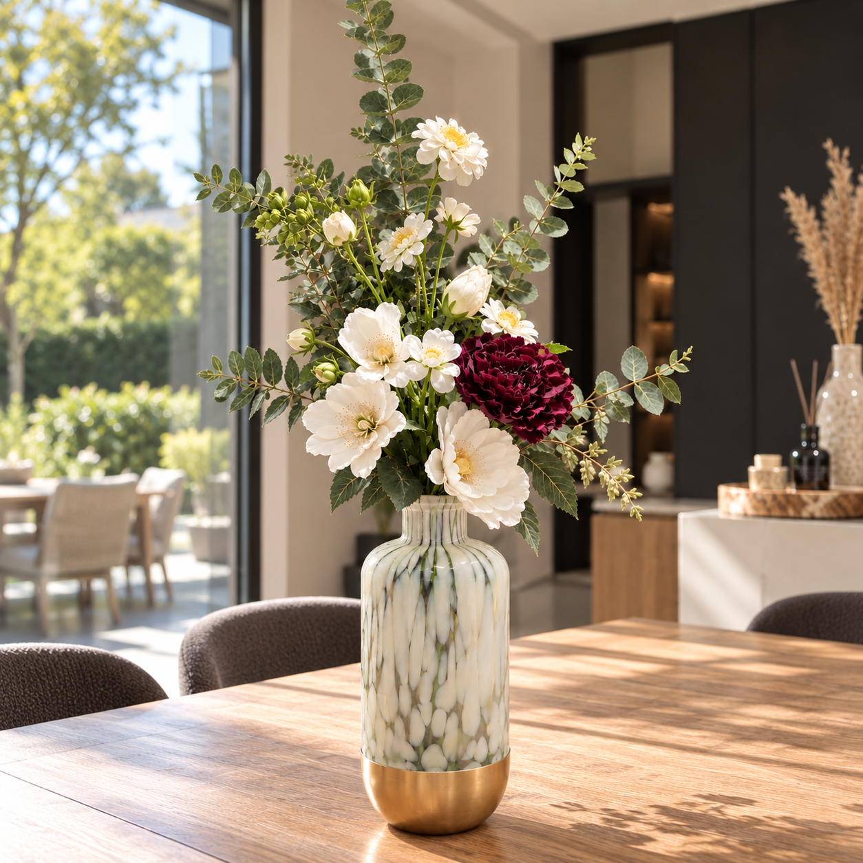 Luxe zijden bloemstuk met witte bloemen, dieprode pioenroos en eucalyptus in een groen-witte designvaas met gouden voet | Luxury silk flower arrangement with white flowers, deep burgundy peony and eucalyptus in a green and white designer vase with gold base